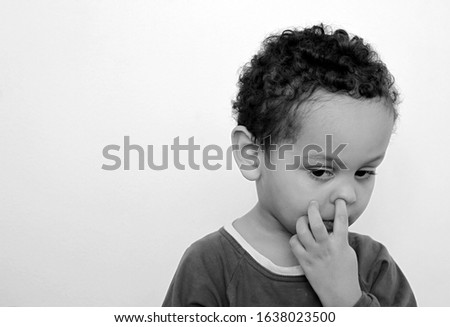 child picking his nose and having fun on white background stock photo