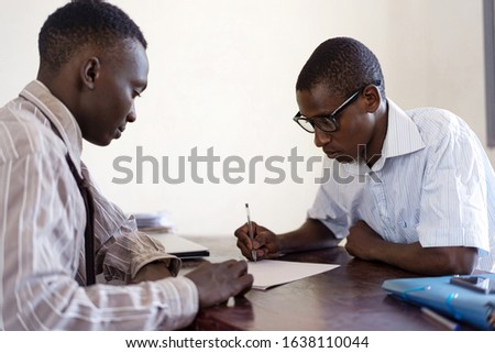 Signing a CV by an African student in front of company's boss, African future symbol