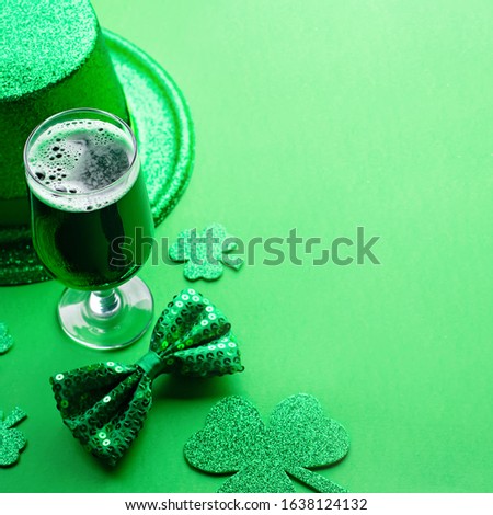 Happy Saint Patrick's Day greeting card with traditional symbols, shamrock, green attire. Green hat, bow tie, St Patricks Day shamrocks, golden confetti on green background, copy space