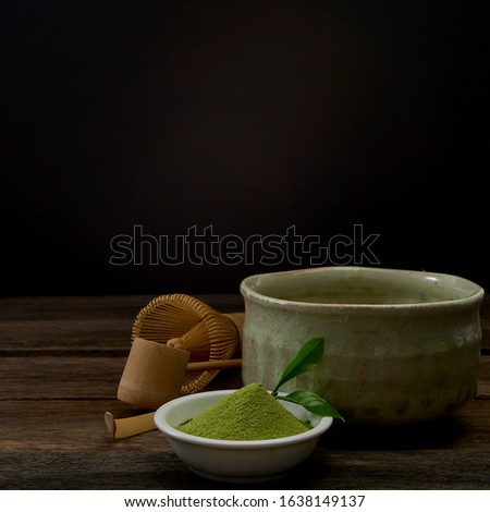 Green Matcha tea bamboo whisk in a bowl on wooden Preparation of powdered green tea