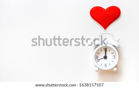 alarm clock with a heart on a white background. Selective focus.