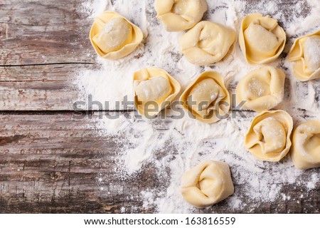 Top view on homemade pasta ravioli over wooden table with flour Royalty-Free Stock Photo #163816559