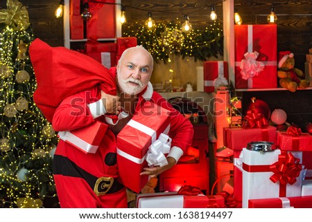 Criminal Santa Claus posing with a bag of christmas gifts. Criminal christmas. Funny bad Santa Claus with gift, bag with presents