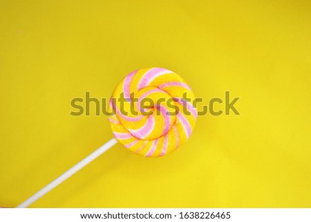 
yellow lollipop on a colored background