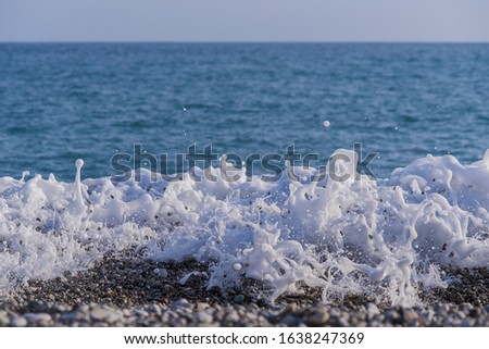 Sea coast with a beautiful soft wave. Transparent blue sea wave with white foam on a clean sandy shore, selective focus. turquoise ocean water. Summertime. Empty sand beach with soft wave background.