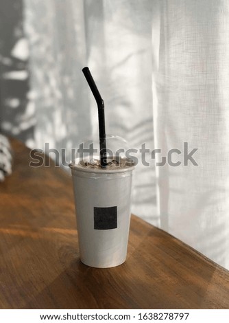 Ice coffee in a tall glass, ready to drink Cool summer drinks on the table are wooden floors.