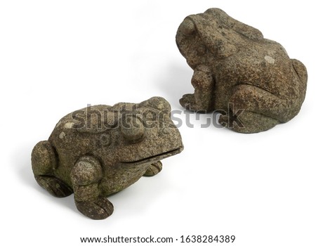 Pair of carved stone stylized frogs. Carved out of granite with moss and lichen on them. 