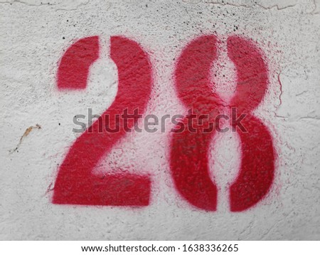 Red Number Twenty eight On The Wall. Spray paint.