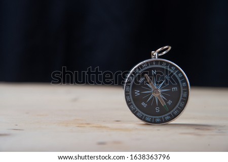 a compass on a wooden table
