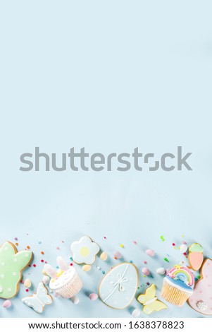 Easter holiday greeting card background. Cute homemade cupcakes with traditional Easter bunny, egg and springtime flowers decor. Happy easter concept. Copy space for your text