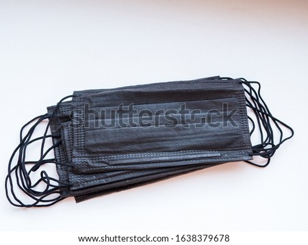 bundle of black surgical mask with rubber ear straps. Typical three-layer surgical mask for covering mouth and nose. (Clipping path). Protection concept