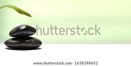 Stack of black stones with leaf. Nature horizontal background. 