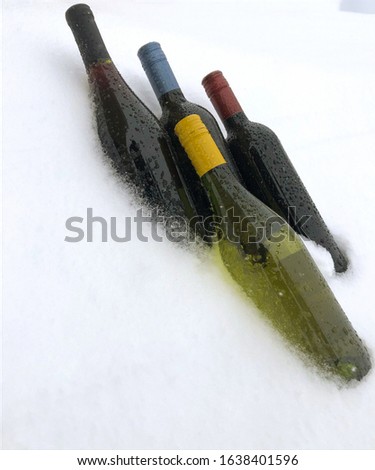 Wine bottles in the snow after the party