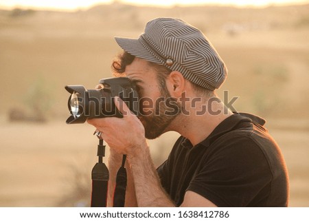 Man with hat taking photos with a digital camera