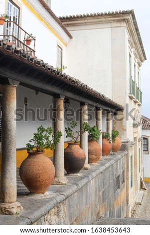 Arcade with ancient pottery with flowers, Óbidos, Portugal
