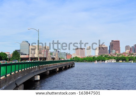 Boston skyline panorama over Charles River with boat, bridge and urban architecture.