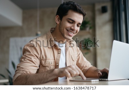 Happy asian student studying, learning language. Attractive business man working start up project in office. Portrait of successful Indian freelancer copywriter using laptop, typing on keyboard. 