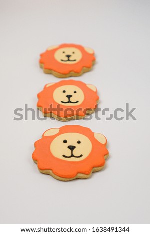 Cookies decorated as lions on a flat surface
