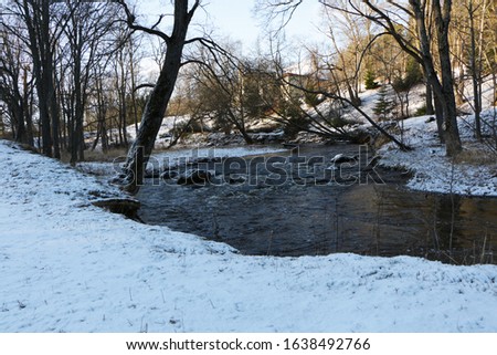 The winding river flows beautifully on a sunny winter day.