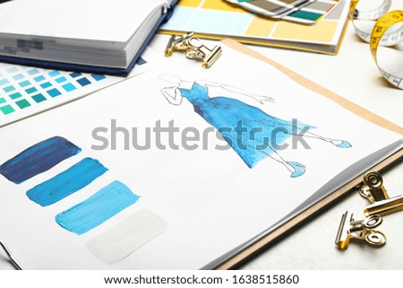 Drawing of dress on white table, closeup. Designer's workplace