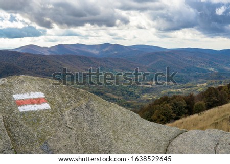 Steep trail at Polonina Wetlinska with red hiking trail. A beautiful view of the Bieszczady mountains from behind the rocks, cloudy warm autumn. Europe, Poland, Podkarpackie Voivodeship, National Park