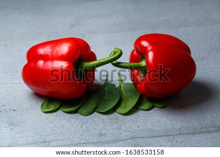 Red pepper with spinach on a gray table