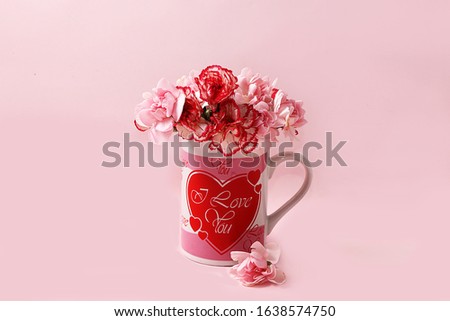 Cup with colors on a pink background. Wishes of a good morning and a good day, minimal holiday concept. Postcard for Women's Day or Valentine's Day, birthday greetings, wedding, gift for loved ones