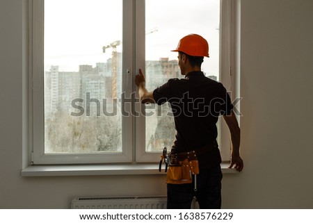 Workman repairing a large picture window