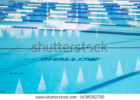 Sunny Outdoor Pool with Lane Ropes in the Shallow End Royalty-Free Stock Photo #1638582700