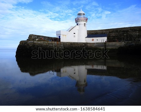 Balbriggan pier with lighthouse reflected in the sea. 