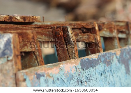 An old wooden fishing boat sits abandoned on the beach.