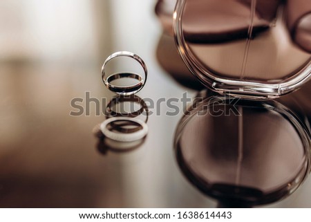 close up wedding gold rings with perfume on a glass table. wedding preparation. copy space