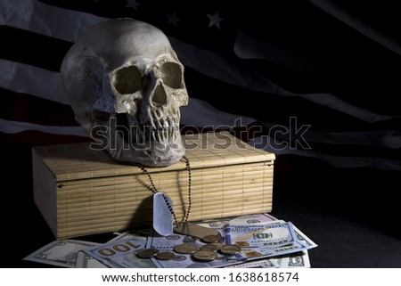 Human skull on the background of the American flag, dollars and military medallions. Concept: military special operations, The price of victory, dead soldiers, benefits and pensions for families