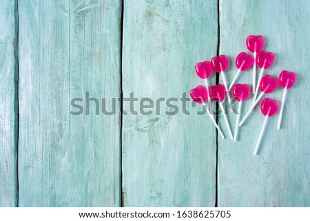 heart-shaped lollipops on turquoise surface