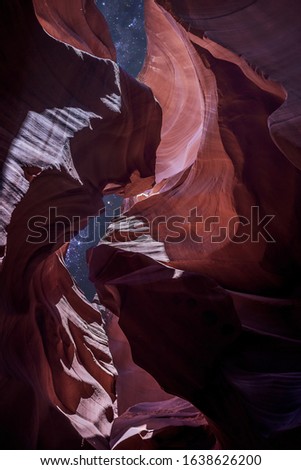 Antelope Canyon's red rock formations under a midnight blue evening sky in Page, Arizona, USA.