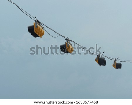 Old-fashioned traffic lights hanging by wires at an intersection