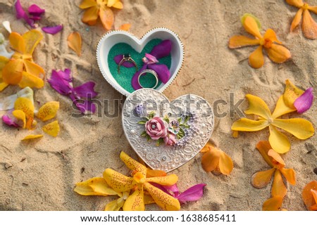 Wedding rings on the beach with the heart box