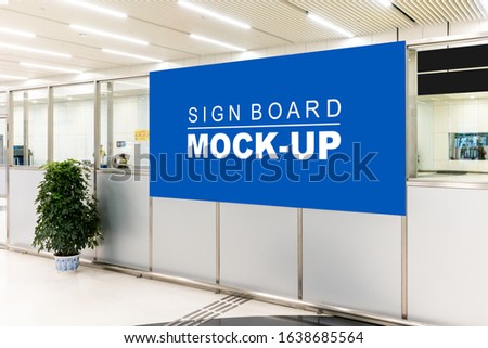 Mock up large blank horizontal billboard with clipping path standing on partition at hall of building, blurred people walking, empty space for advertising or information media