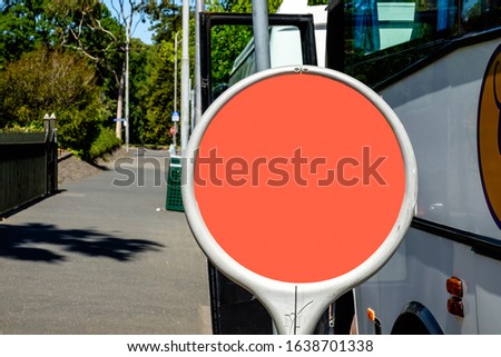 Close-up shot of circular bus stop sign template  or copy space with orange background, installed on a metal pole at footpath of Melbourne