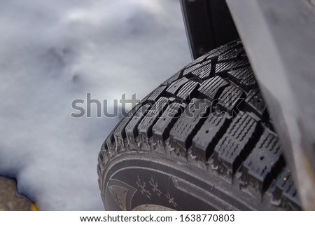 A severe weather rated front driver side, snow and ice tire, with stud holes. This is also an off road tire.  Royalty-Free Stock Photo #1638770803