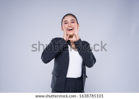 An attractive woman wearing business attire with gestures towards copyspace area isolated on grey. Good for manipulation works for technology, transportation, business or finance theme.