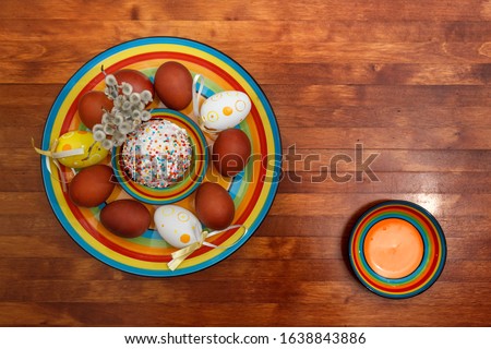 Easter cake with painted eggs on a table made of natural wood