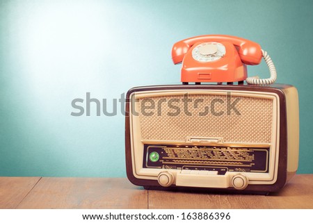 Vintage old radio, retro telephone on wooden table