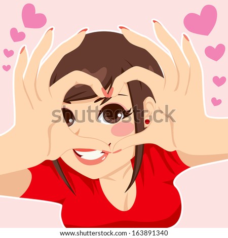Beautiful brunette teenager girl looking through love heart hand sign