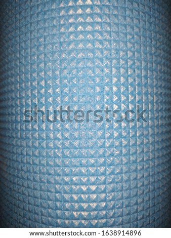 The blue background of small squares is curved in the shape of a cylinder convex in the center and slightly curved inwards at the edges the corners are darkened.