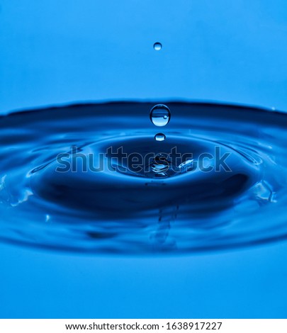 water drop splash blue colored. Round water drop. Water drop in glass. Drops, splashes, spray, abstract shapes out of the water Royalty-Free Stock Photo #1638917227