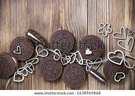 chocolate chip cookie sandwich on a wooden surface. hearts of wood strung on a rope. Happy Valentine's day. Nice picture with a biscuits. wooden background. texture.