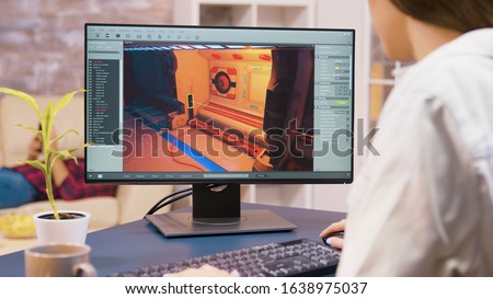 Close up shot of young woman game developer working on a new video game level in her house Royalty-Free Stock Photo #1638975037