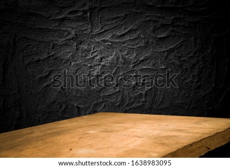 Empty wooden table on a background of dark blurred wall, empty space for product above