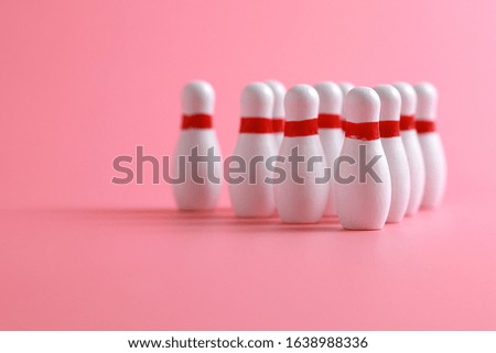 Closeup of a wooden mini bowling game set and pins on pink background